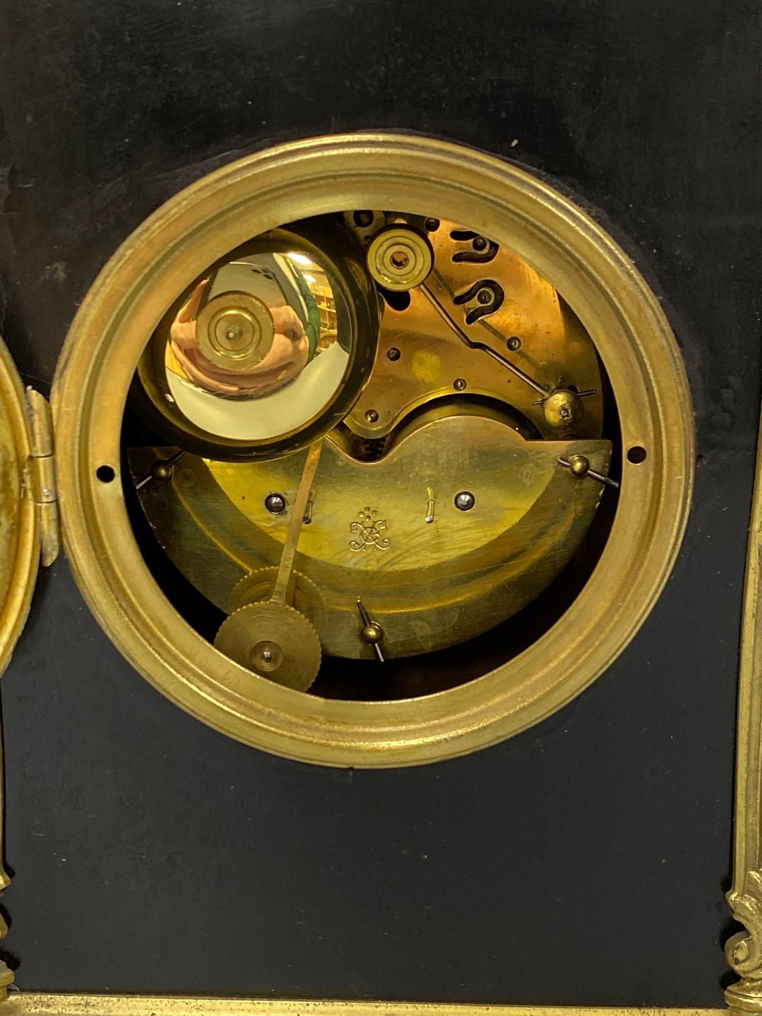 A French ebonised mantel clock with cast brass mounts, 9cm convex enamel dial, bell striking movement, height 27cm incl. handle